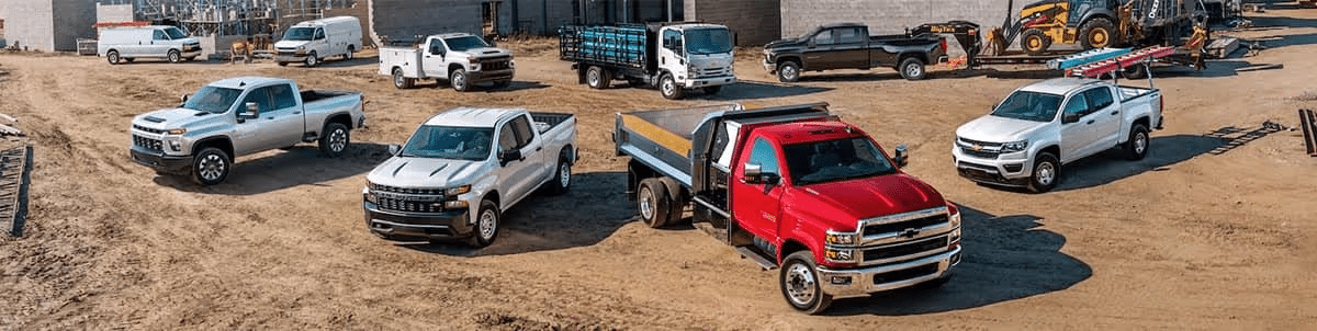 A diverse fleet of Chevy trucks at a construction site, showcasing durability and utility.