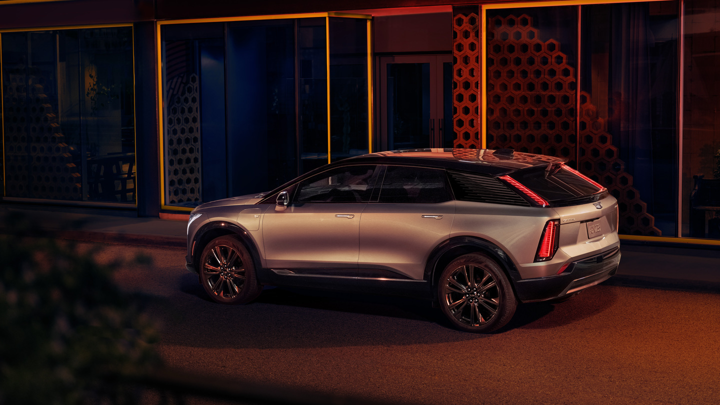 Sleek silver SUV parked in front of a building with illuminated hexagonal design elements.